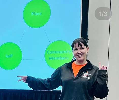 Andrea Sirois standing in front of a screen