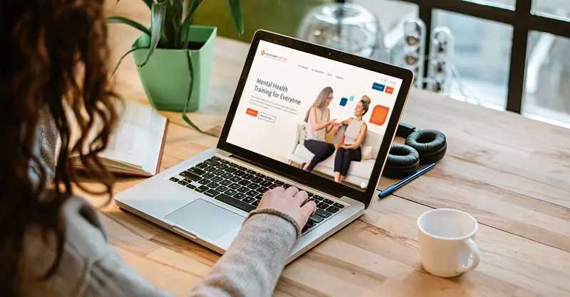 a woman looks at the MHFA on a laptop