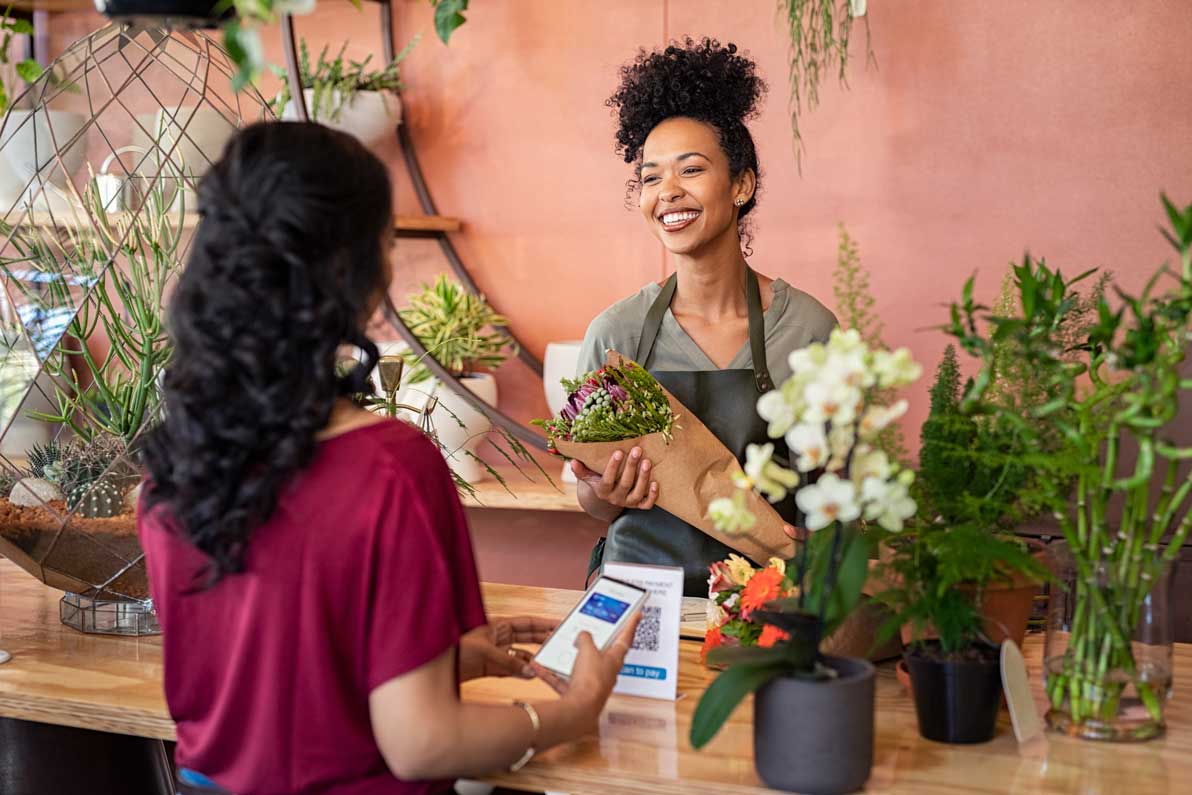 a woman buys flowers in a flower shop from a female employee