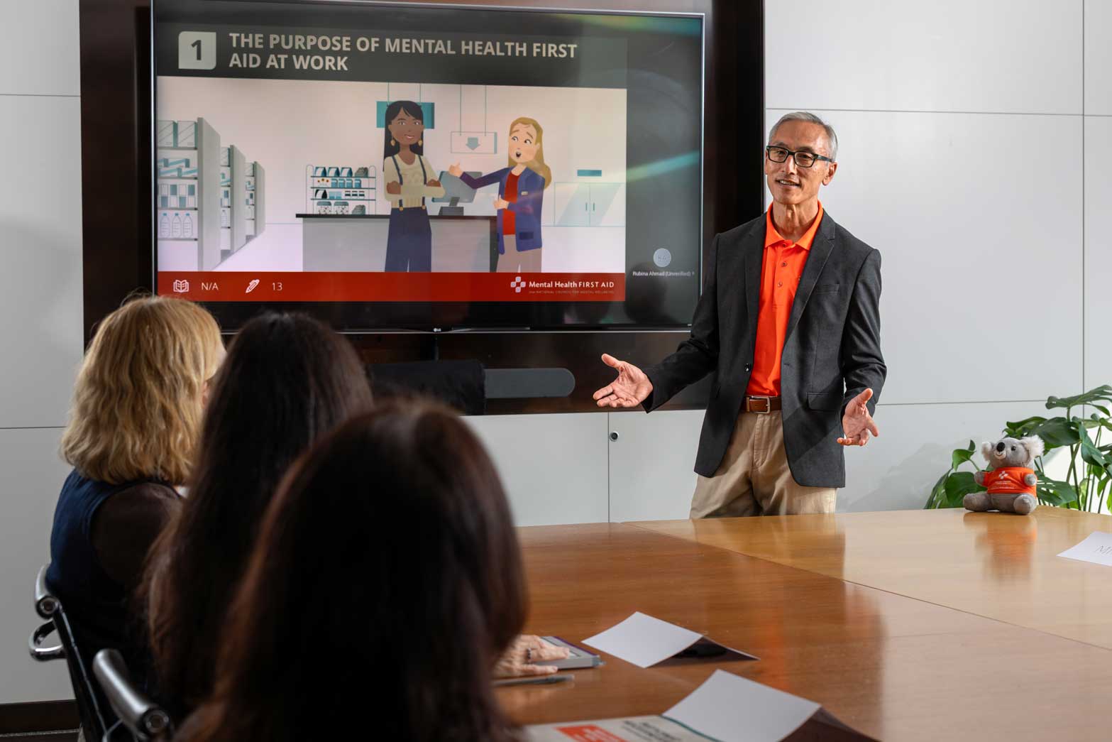 a man teaches mhfa to employees in a conference room