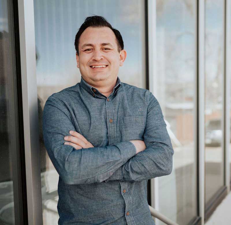 image of david galvan standing in front of windows with his arms crossed
