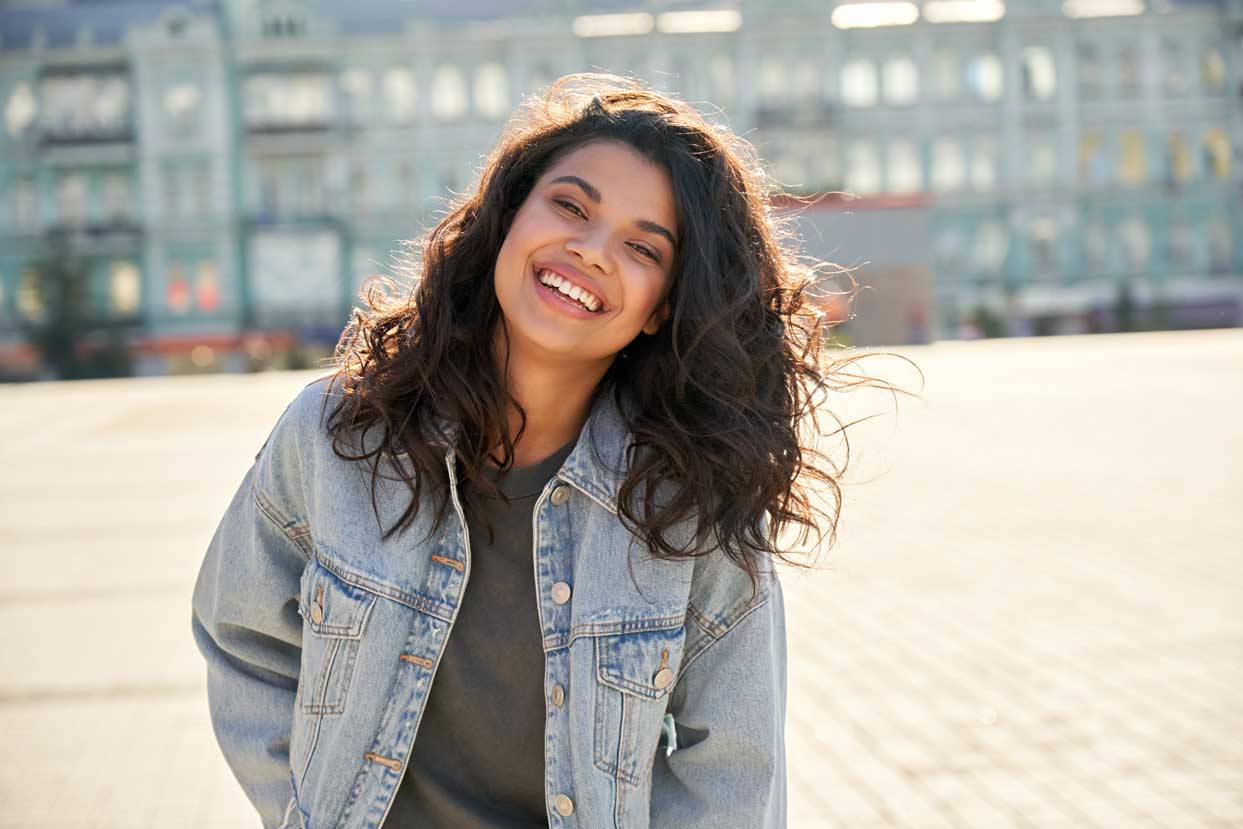 a teen smiles outside