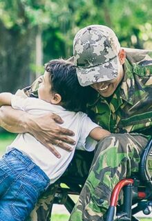 a veteran in a wheelchair hugging their children
