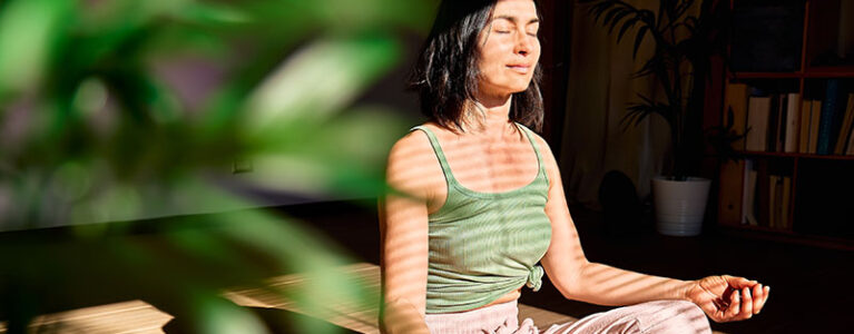 a woman sitting with legs crossed and eyes closed