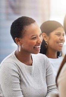 employees sit in a meeting smiling