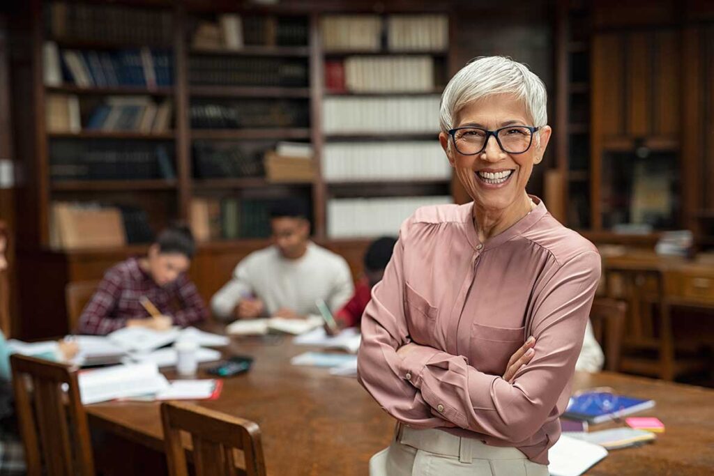 a woman stands in front of a table in a library