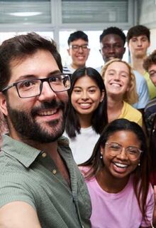 a group of college students take a selfie in a classroom