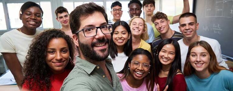 a group of college students take a selfie in a classroom